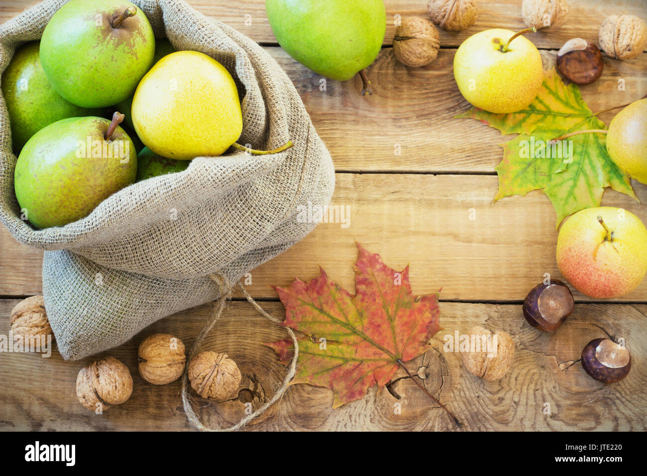 In autunno la composizione di frutta e spezie - pere e noci, foglie di acero su uno sfondo di legno Foto Stock
