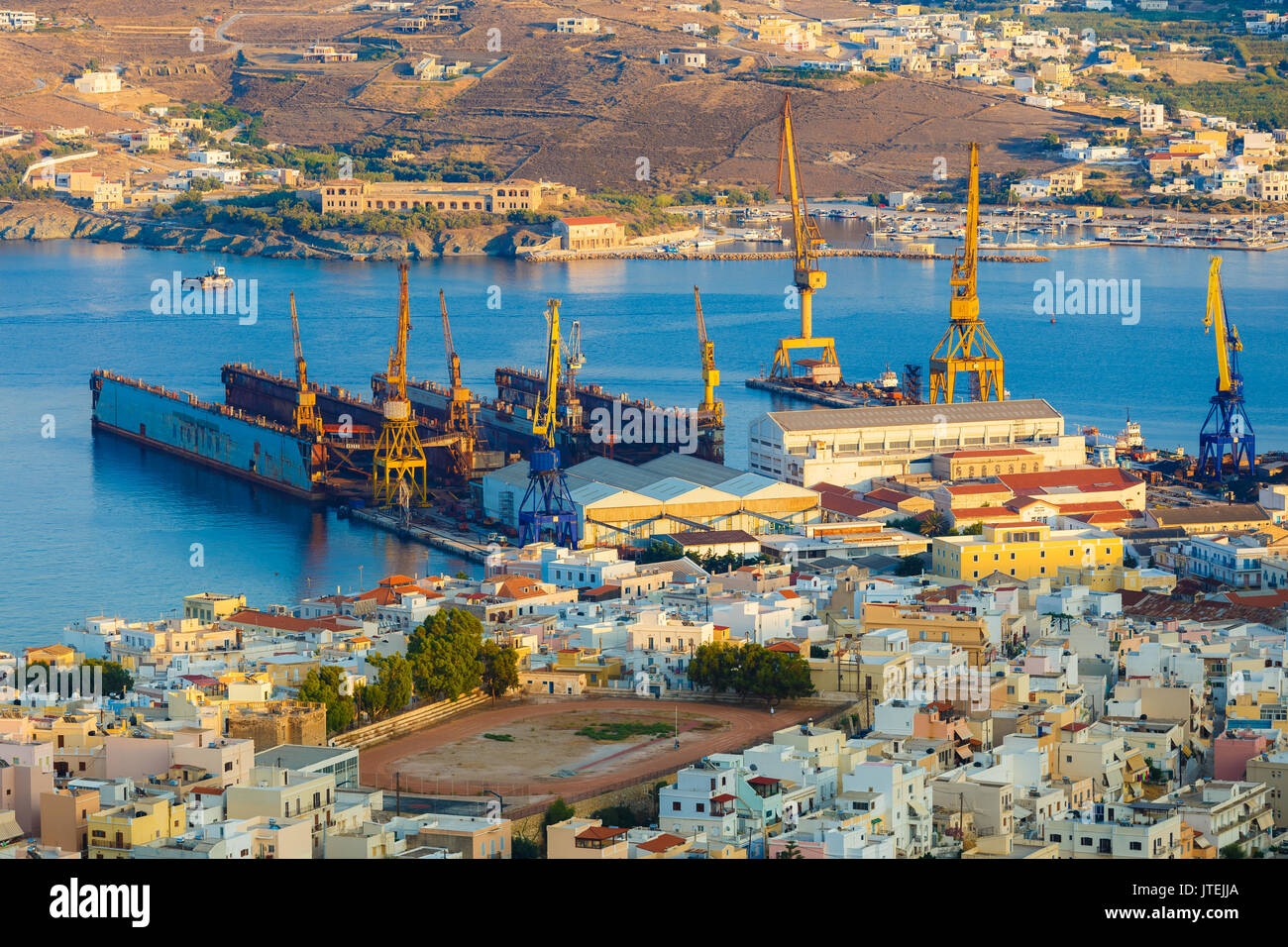 Ermoupolis o porta Hermoupolis e edifici di distanza al crepuscolo.Ermoupolis è una città e ex comune sull'isola di Syros, Cicladi Grecia Foto Stock