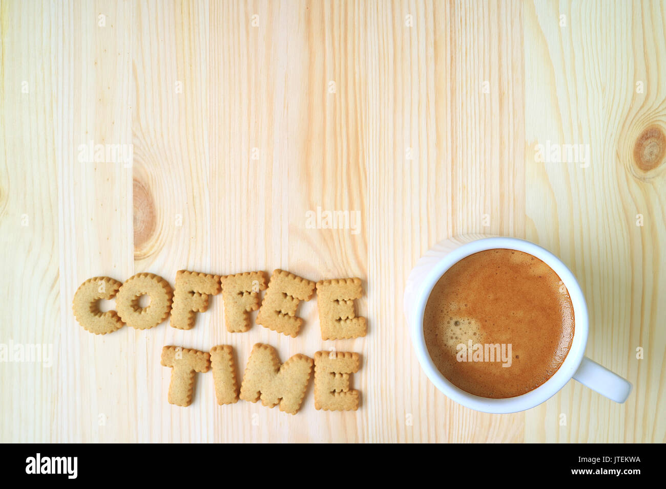 Vista superiore della parola caffè tempo ortografia con alfabeto biscotti di forma e una tazza di caffè sul tavolo di legno con lo spazio libero per il testo e il design Foto Stock