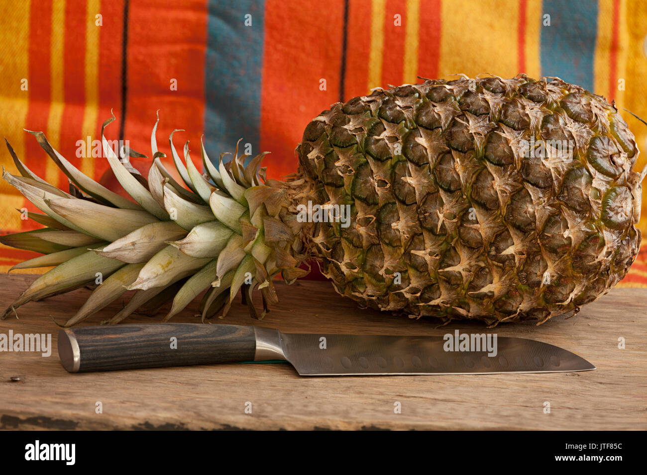 Di ananas maturo e un coltello di grandi dimensioni sul tavolo prima di cuocere ancora vita Foto Stock