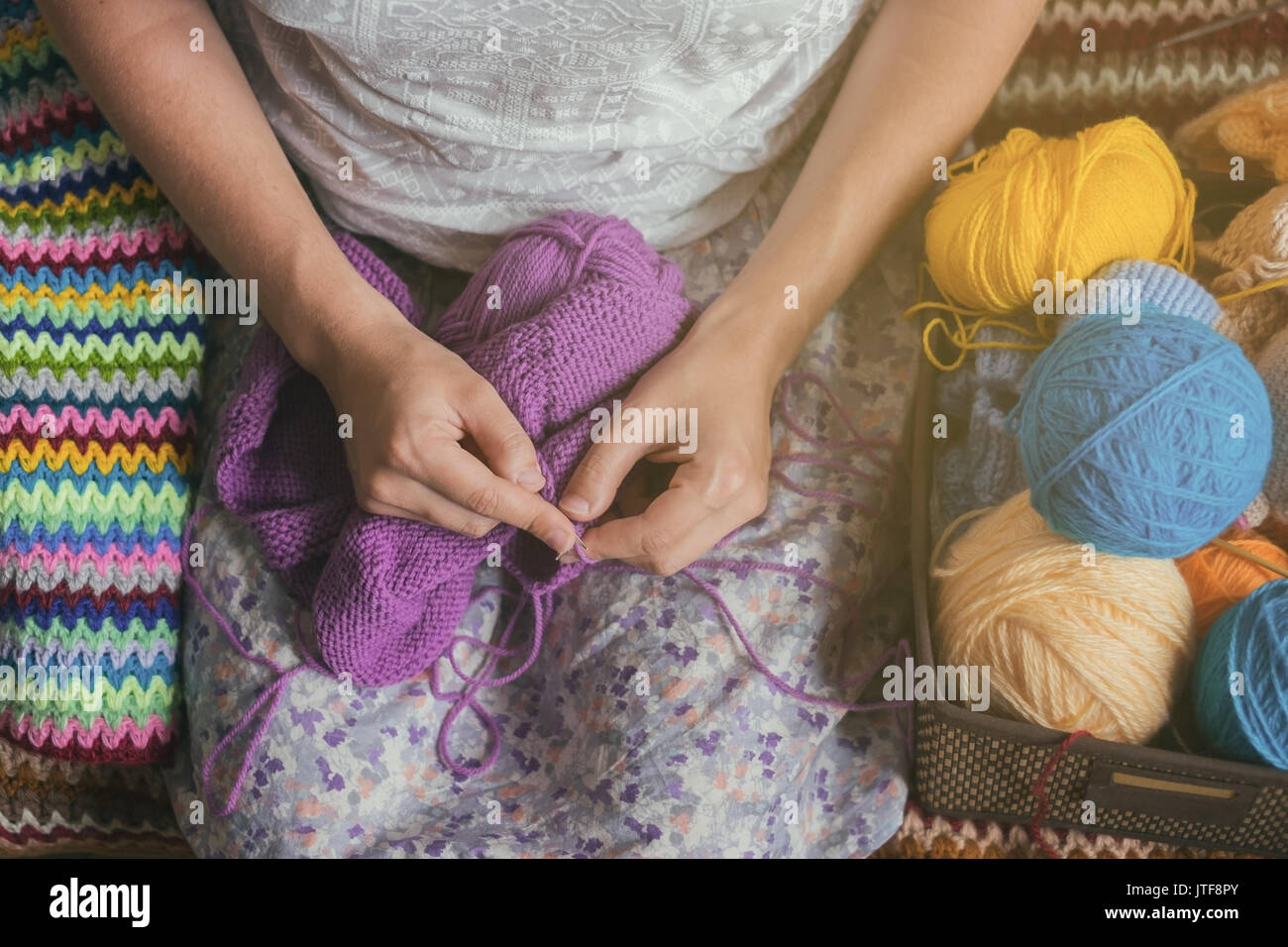 La donna caucasica maglieria panni di lana. Tenendo degli aghi di tessitura a mano Foto Stock