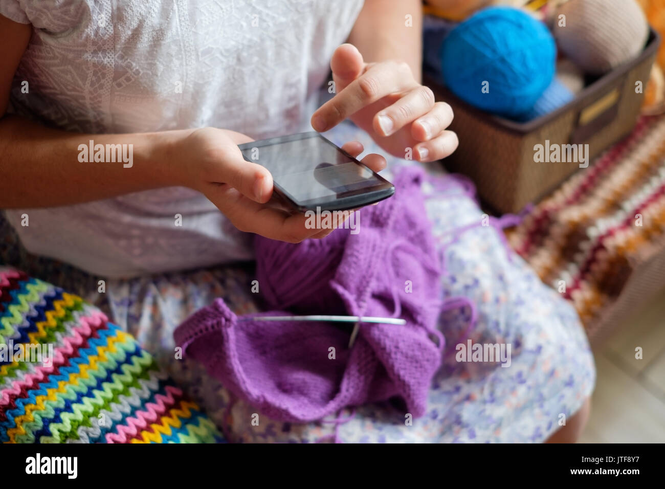 La donna caucasica maglieria panni di lana. Tenendo degli aghi di tessitura a mano Foto Stock