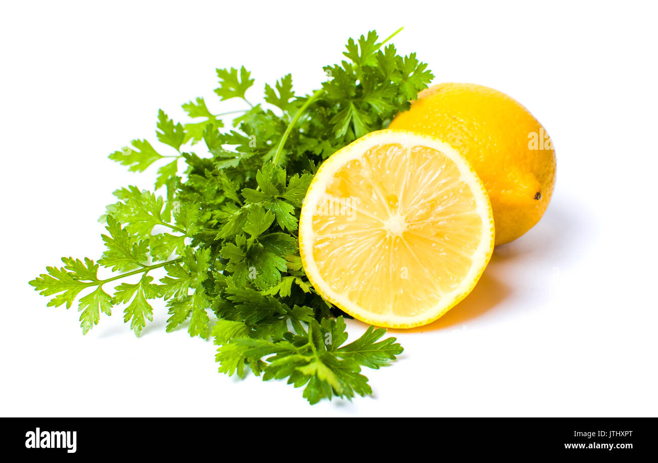 Limone e foglie di prezzemolo isolato su bianco Foto Stock