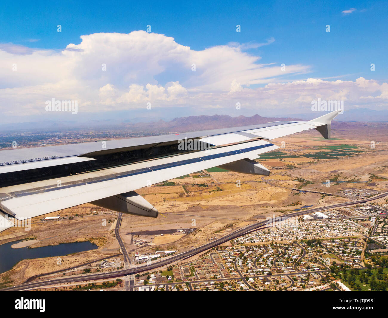 Airbus A320 ala con spoiler di volo e lembi posteriori parzialmente dispiegato sull approccio all'Aeroporto Internazionale Sky Harbor di Phoenix. Distanza temporale. Foto Stock