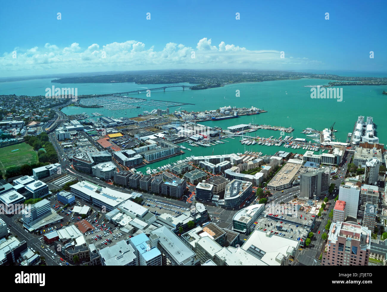 Panoramica vista aerea della città di Auckland e dal porto di Waitemata guardando verso nord-ovest per l'iconica Auckland Harbour Bridge in distanza. In foregroun Foto Stock