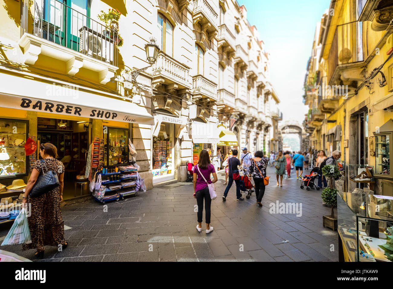 I turisti e i locali shop e vagare il Corso Umberto, la strada principale del villaggio o città di Taormina in Sicilia Foto Stock