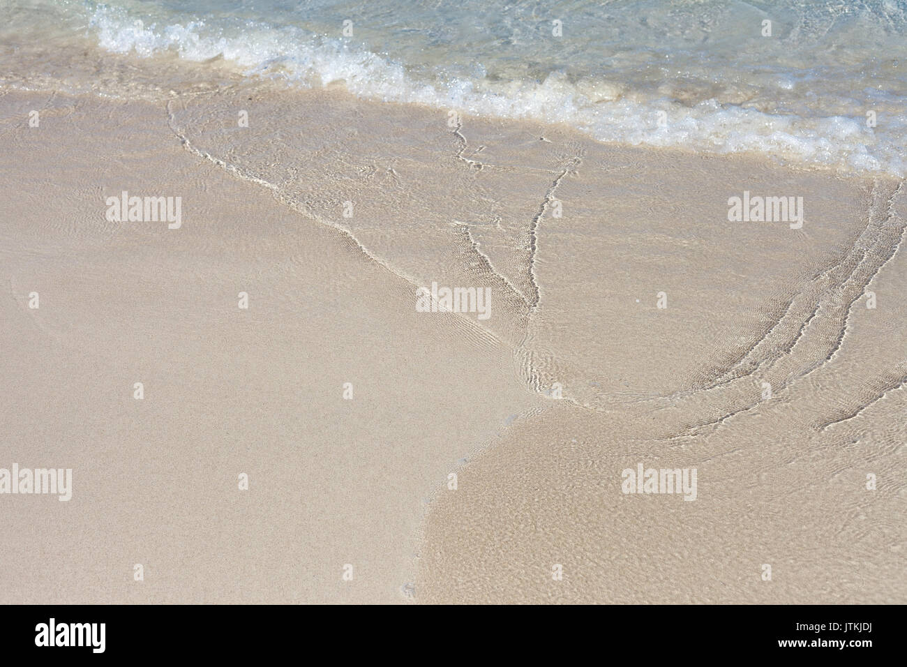 Onda morbida di colore blu oceano su una spiaggia di sabbia. Sfondo. Messa a fuoco selettiva. Foto Stock