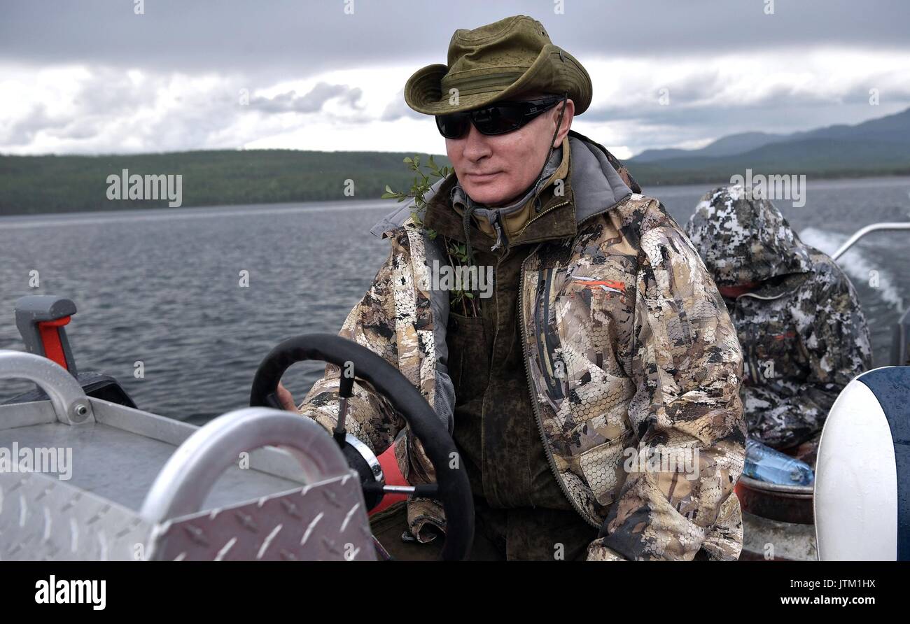 Il presidente russo Vladimir Putin dietro al volante di una powerboat dopo la pesca su un lago remoto durante un'avventura nel deserto siberiano in prossimità della frontiera mongola agosto 1-3, 2017 nella Repubblica Tyva, Russia. Foto Stock