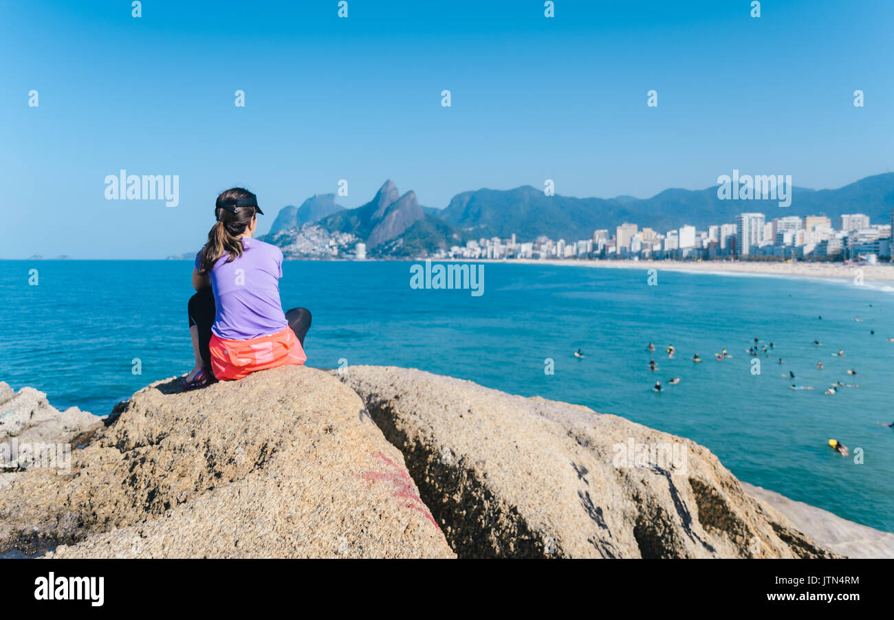 Donna (30-35) guardando alla vista della spiaggia di Ipanema a Rio de Janeiro in Brasile Foto Stock
