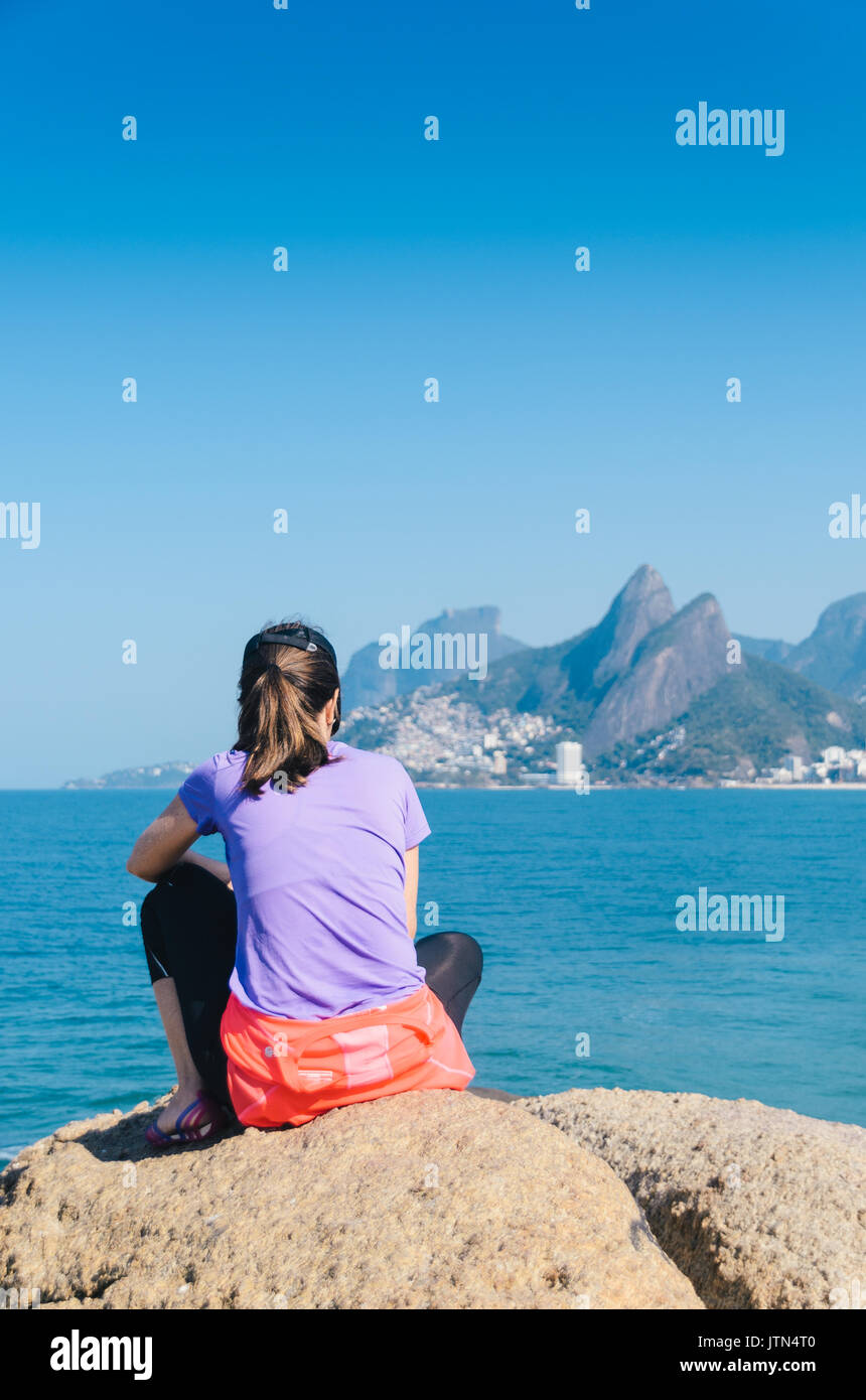 Donna (30-35) guardando alla vista della spiaggia di Ipanema a Rio de Janeiro in Brasile Foto Stock