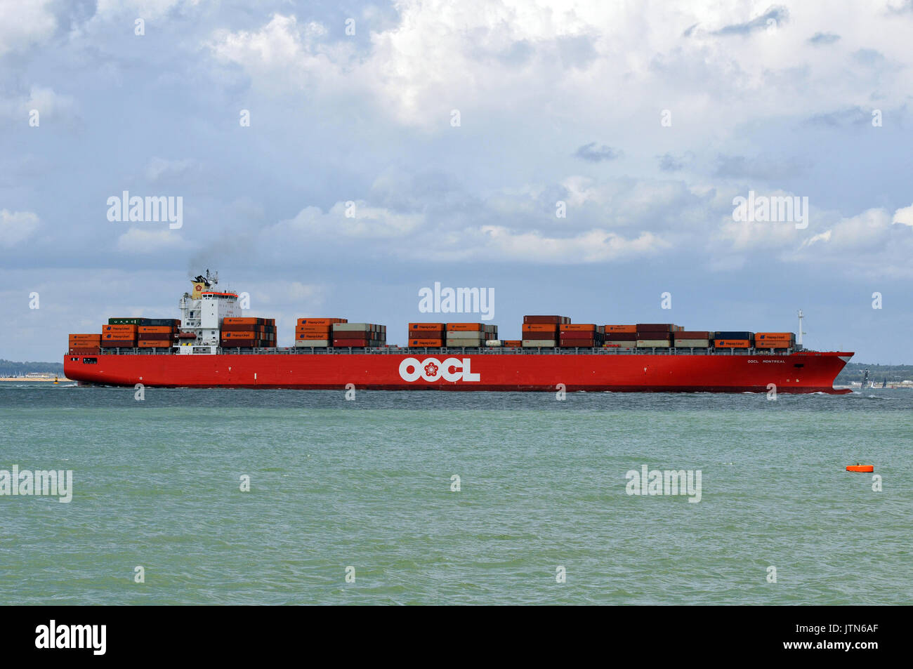 Un grande contenitore nave o imbarcazione di entrare o uscire dal porto di Southampton docks che trasportava un carico di scatole o contenitori caricati sul ponte o tenere premuto Foto Stock