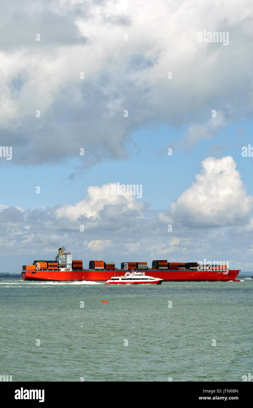 Un grande contenitore nave o imbarcazione di entrare o uscire dal porto di Southampton docks che trasportava un carico di scatole o contenitori caricati sul ponte o tenere premuto Foto Stock