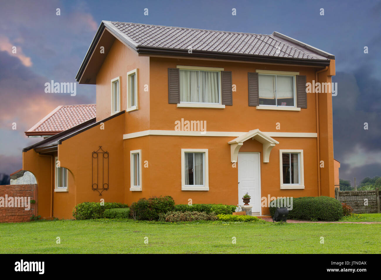 Casa italiana modello- con il bellissimo paesaggio e le nuvole drammatico. Foto Stock