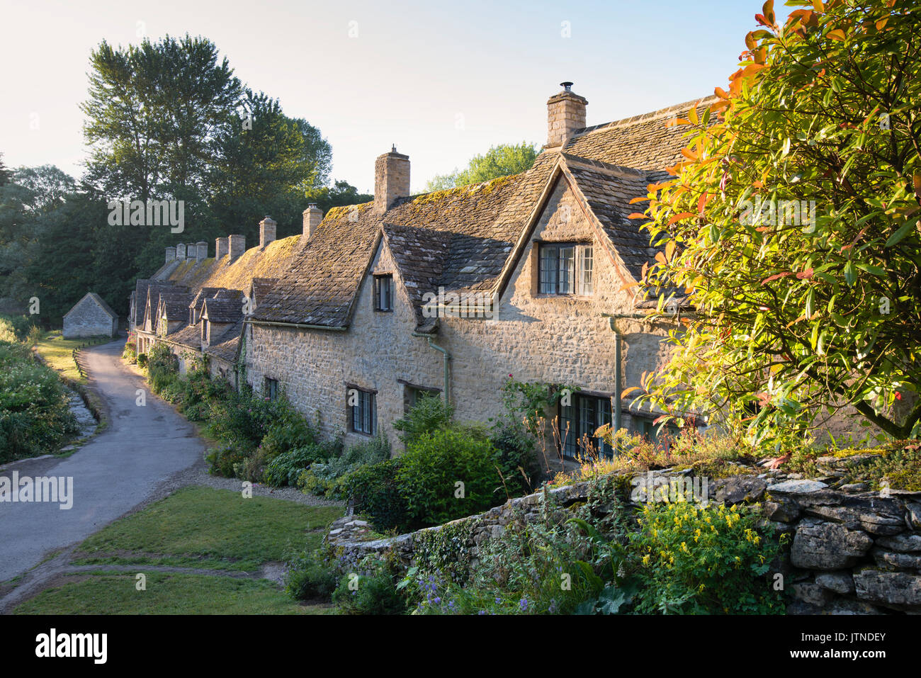 La mattina presto luce solare su Arlington Row. Bibury, Cotswolds, Gloucestershire, Inghilterra Foto Stock