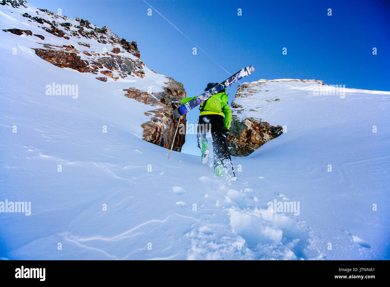 Un uomo escursionismo fino a sciare il sentire delle tenebre Couloir in Wasatch Backcountry, Utah Foto Stock