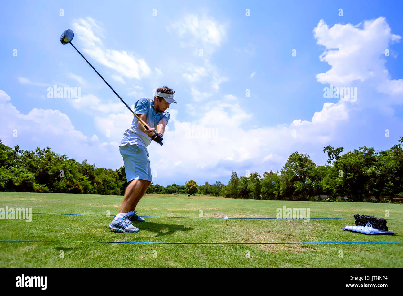 Giovane uomo giocando a golf, Bali, Indonesia Foto Stock