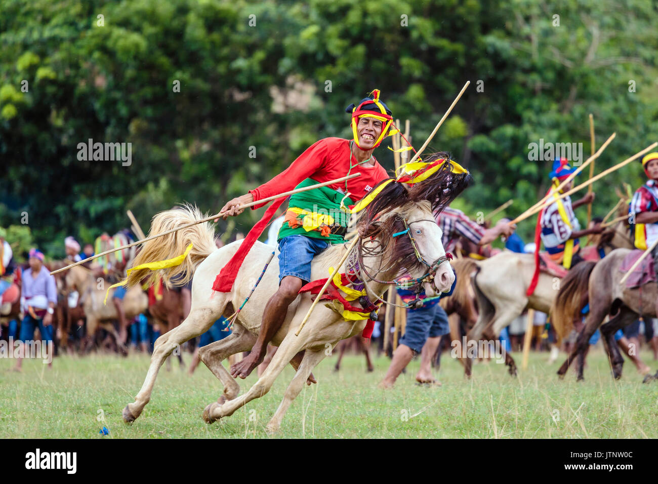 Uomo a cavallo con lancia e concorrenti a Pasola Festival, isola di Sumba, Indonesia Foto Stock