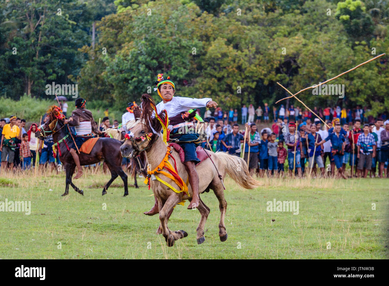 Uomini a cavallo e gettando lancia a Pasola Festival, isola di Sumba, Indonesia Foto Stock