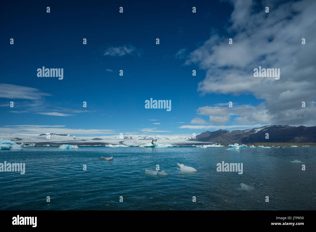Islanda - Cloud dividendo il cielo blu turchese su ghiaccio sul lago glaciale Foto Stock