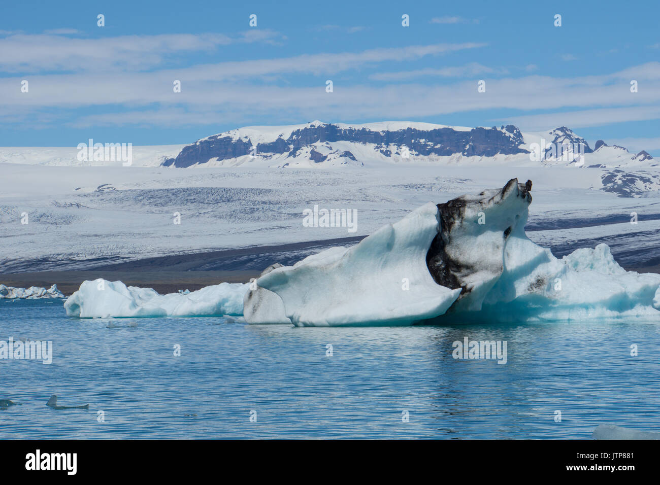 Islanda - Impressionante iceberg alla deriva nel lago glaciale con il ghiacciaio in background Foto Stock