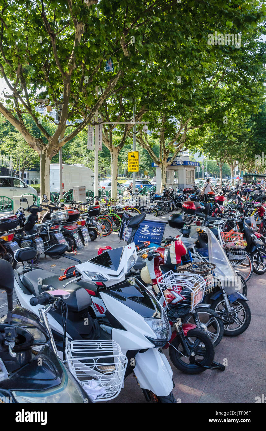 Scooter e biciclette sono popolari mezzi di trasporto in Shaghai e sono spesso visto parcheggiati sul lato se la strada o presso centri commerciali. Foto Stock