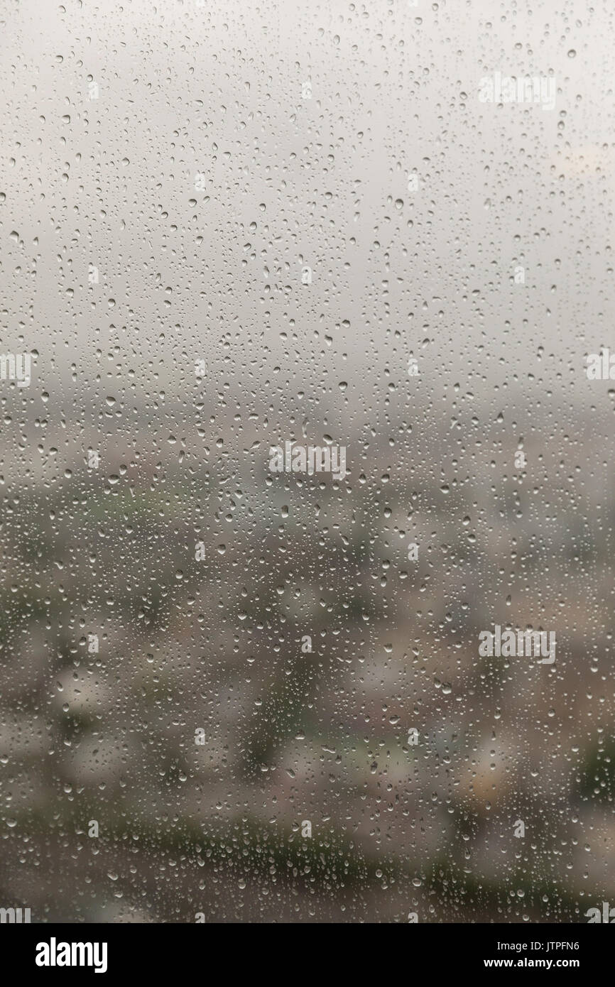 Grigia giornata piovosa a Londra vista attraverso il alto della finestra con gocce di pioggia Foto Stock