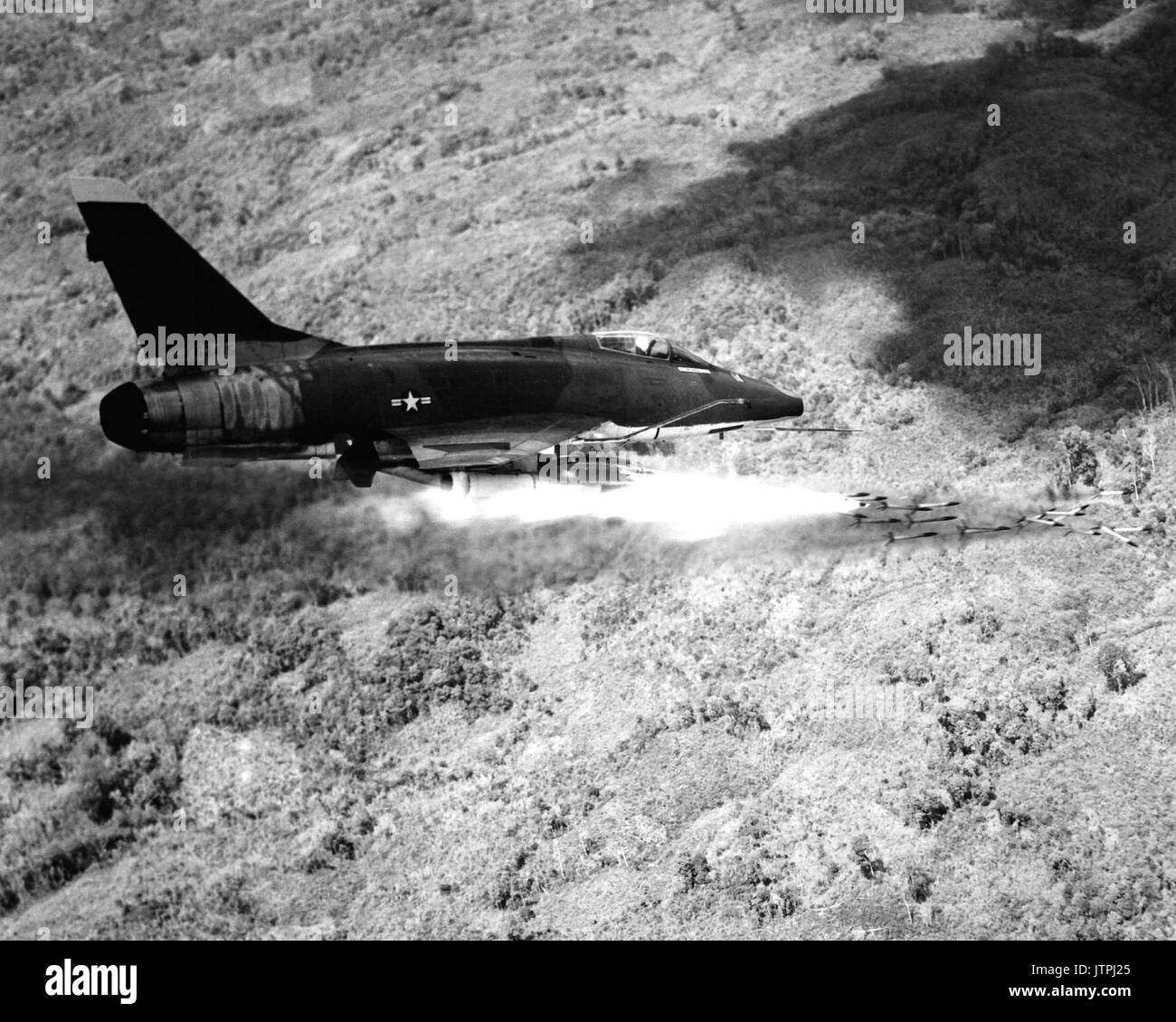 Una forza aerea F-100D Super Sabre incendi di aeromobili di un salvo di 2,75 pollici di razzi contro un nemico posizione nel Vietnam del Sud. Super Sabre piloti sono noti per la loro accuratezza durante i bombardamenti e bombardamento corre con il supersonico fighter. Foto Stock