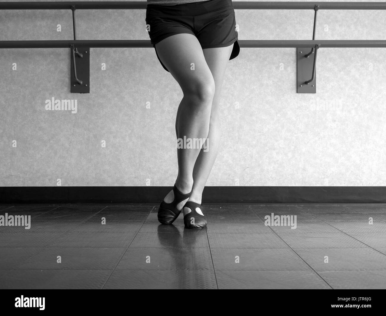 Versione in bianco e nero della danzatrice con piede smussato in Jazz posizione di scavo Foto Stock
