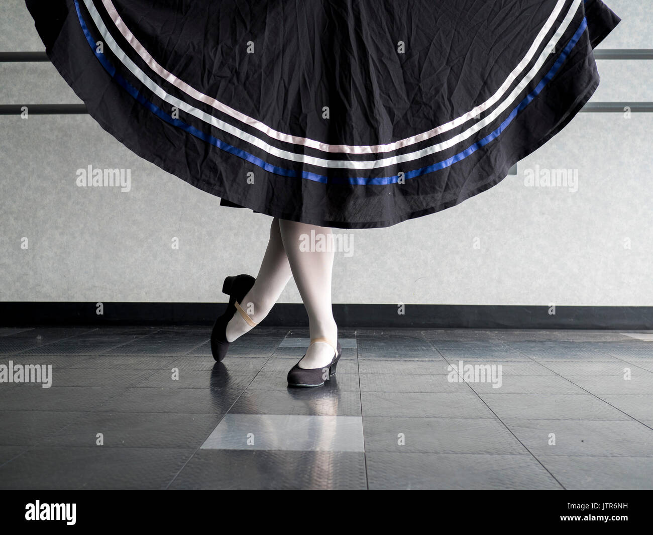 Ballerina nella posizione classica con mantello tenutasi a carattere abbigliamento di balletto Foto Stock