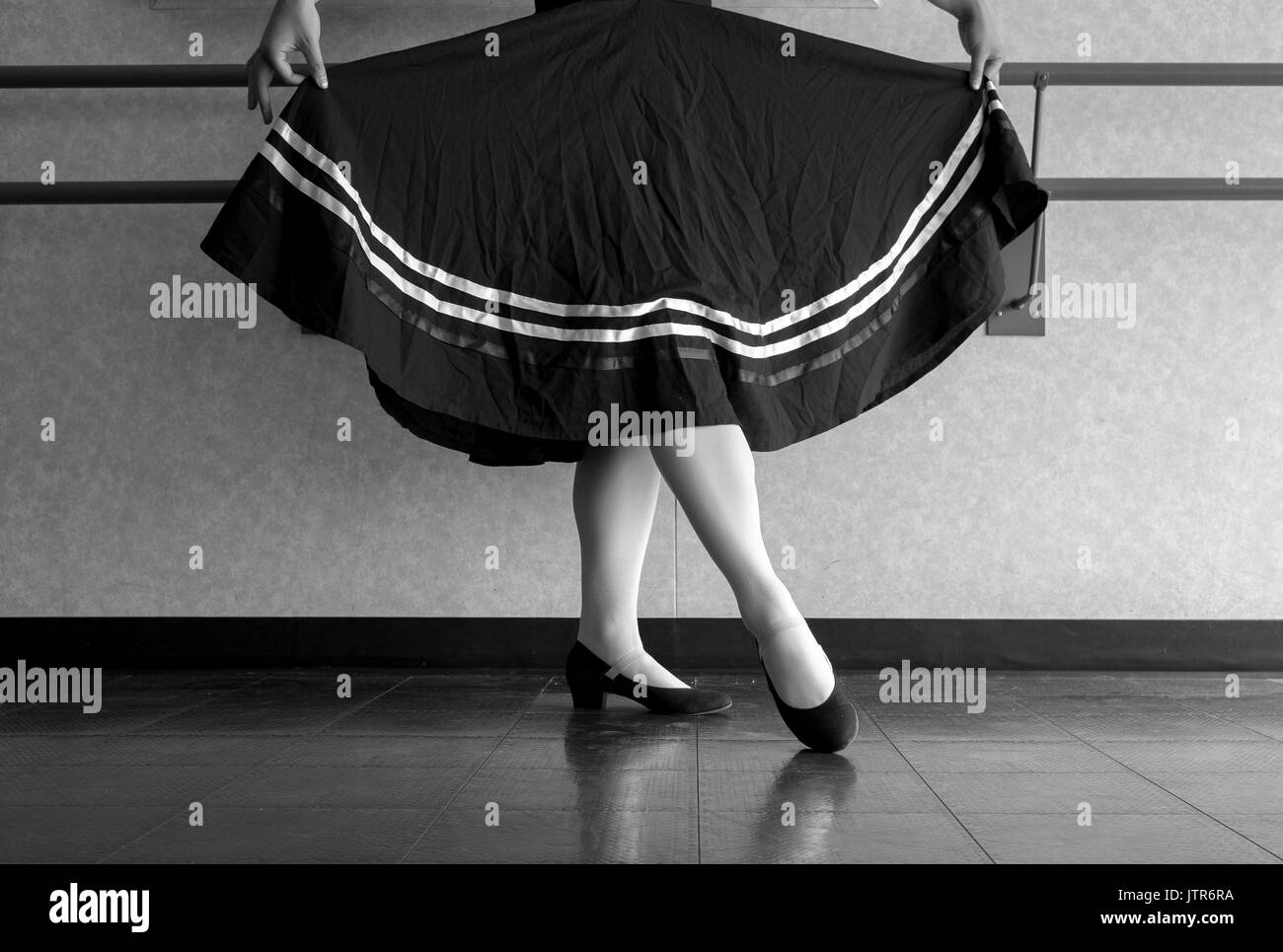 Versione in bianco e nero di adolescente facendo balletto di carattere danza con mantello tenuto in preparazione Foto Stock