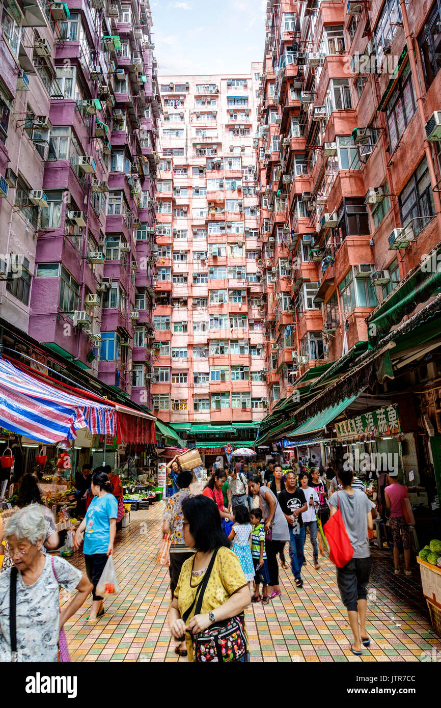 HONG KONG, Luglio 6, 2017: una folla di acquirenti di mattina in un mercato di strada sotto le affollate appartamenti a Hong Kong del vecchio quartiere residenziale di Quar Foto Stock