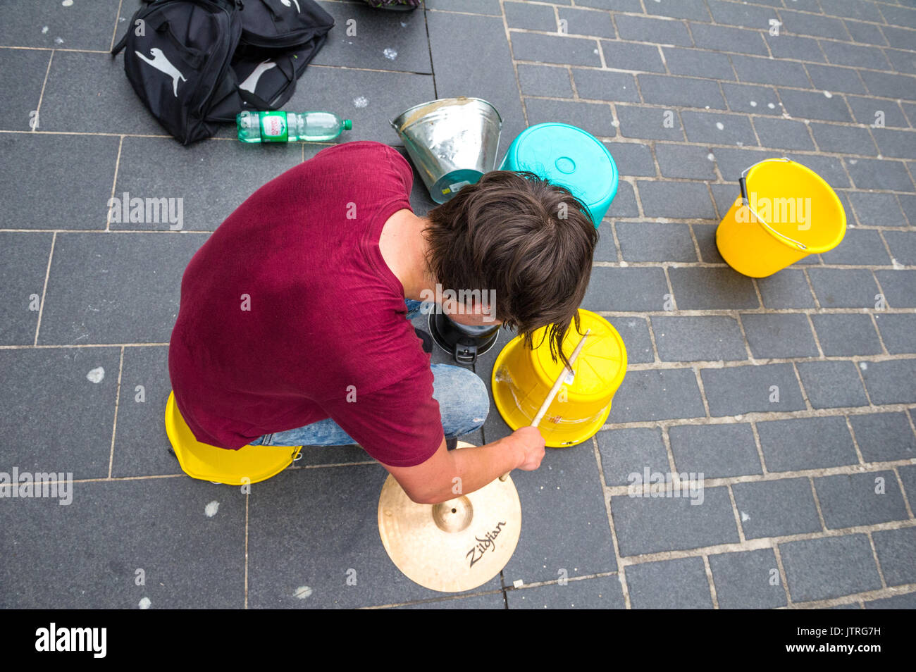 Musicista di strada maschio nel occupato le strade dello shopping Liverpool utilizzando secchielli in plastica e un barattolo di latta. Foto Stock