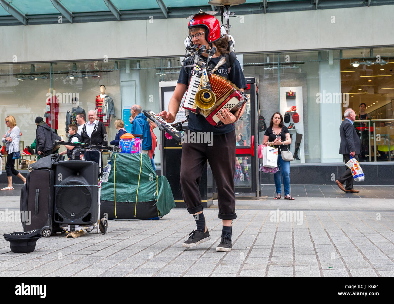 One man band musicista di strada nella trafficata strade dello shopping di Liverpool utilizzando un certo numero di strumenti musicali, Foto Stock