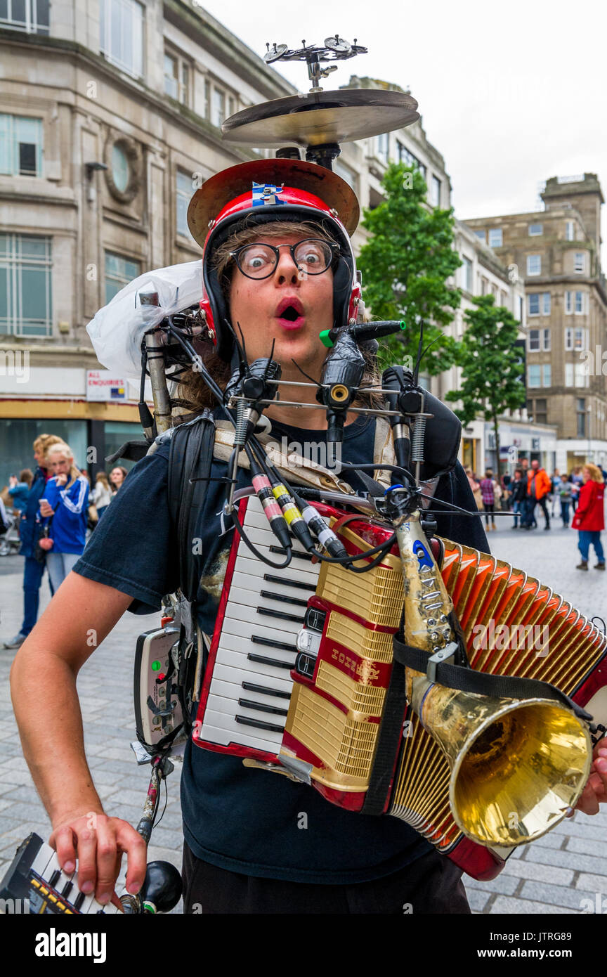 One man band musicista di strada nella trafficata strade dello shopping di Liverpool utilizzando un certo numero di strumenti musicali, Foto Stock