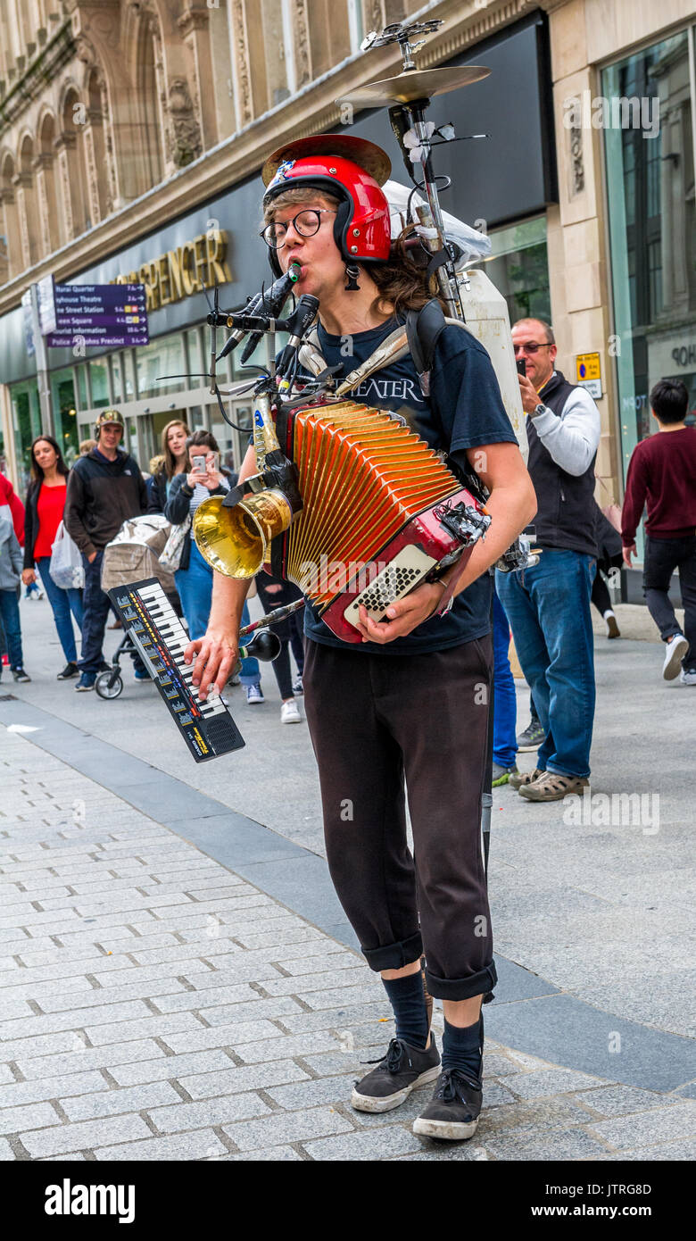 One man band musicista di strada nella trafficata strade dello shopping di Liverpool utilizzando un certo numero di strumenti musicali, Foto Stock