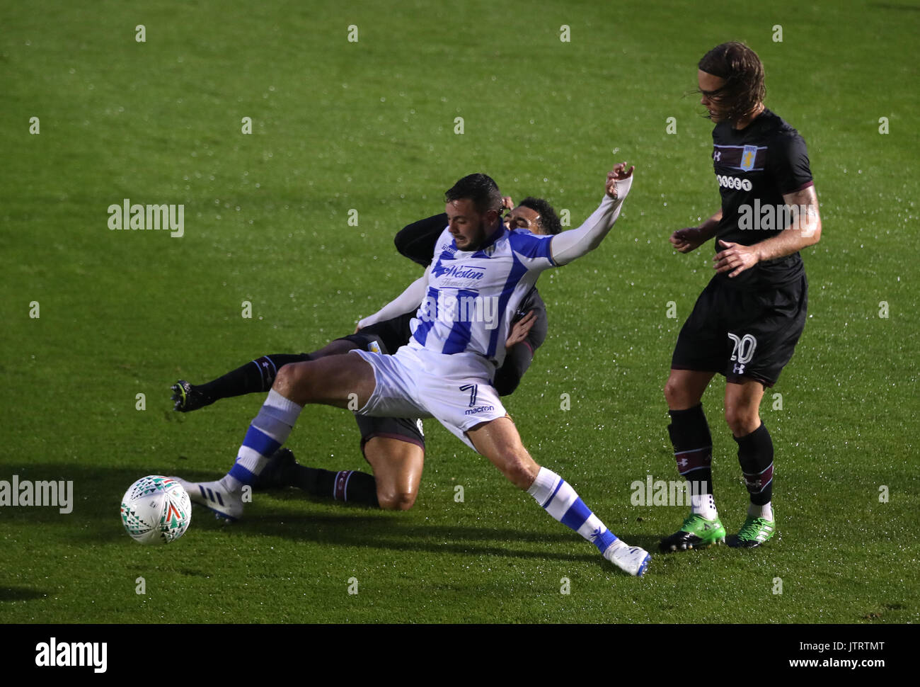 Colchester United Drey Wright (anteriore) e Aston Villa di Andre verde battaglia per la sfera durante il Carabao Cup, primo round in abbinamento a Weston Homes Comunità Stadium, Colchester. Foto Stock