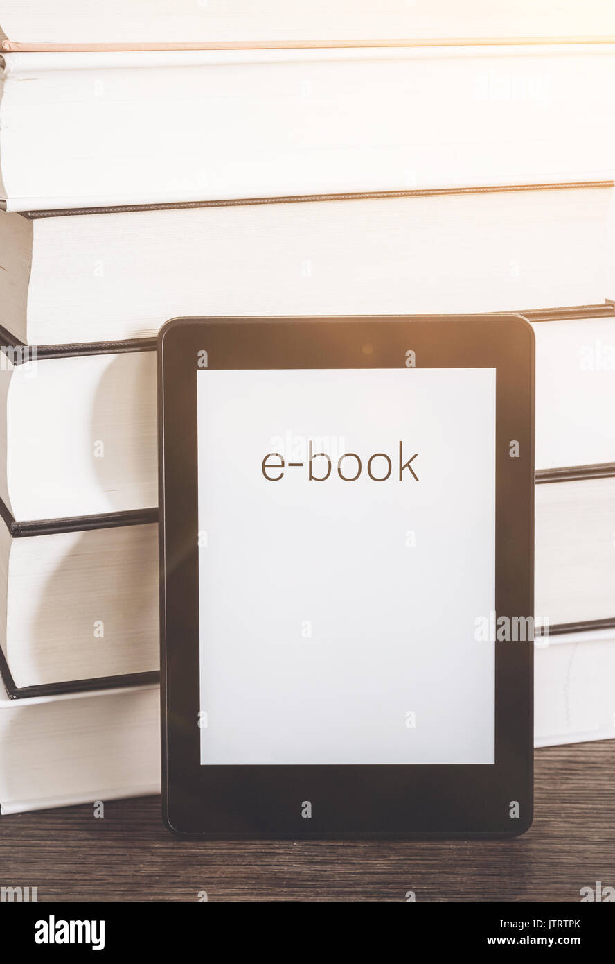 Lettore di e-book su una pila di libri su tavola in legno rustico concetto Foto Stock