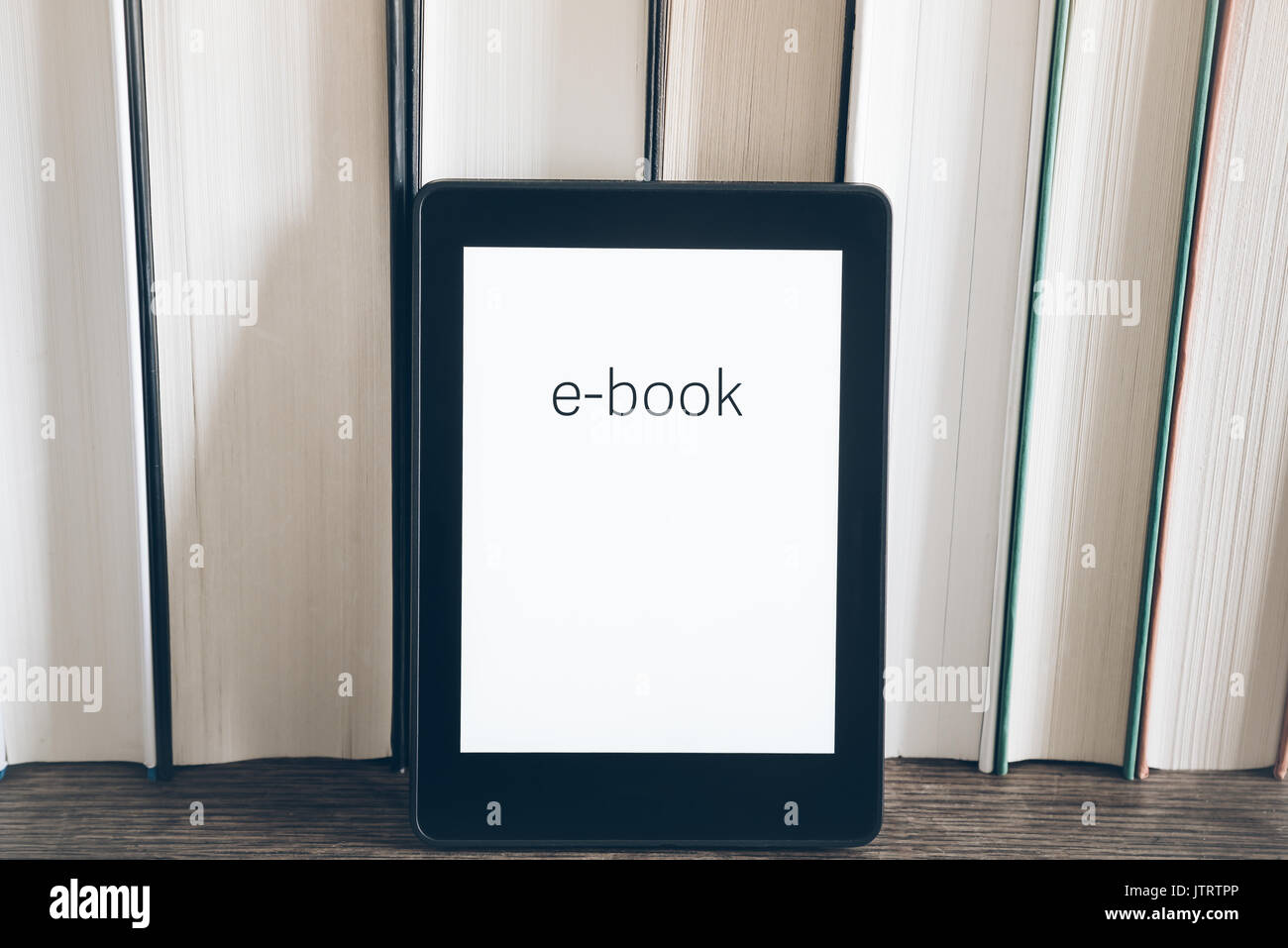 Lettore di e-book su una pila di libri su tavola in legno rustico concetto Foto Stock