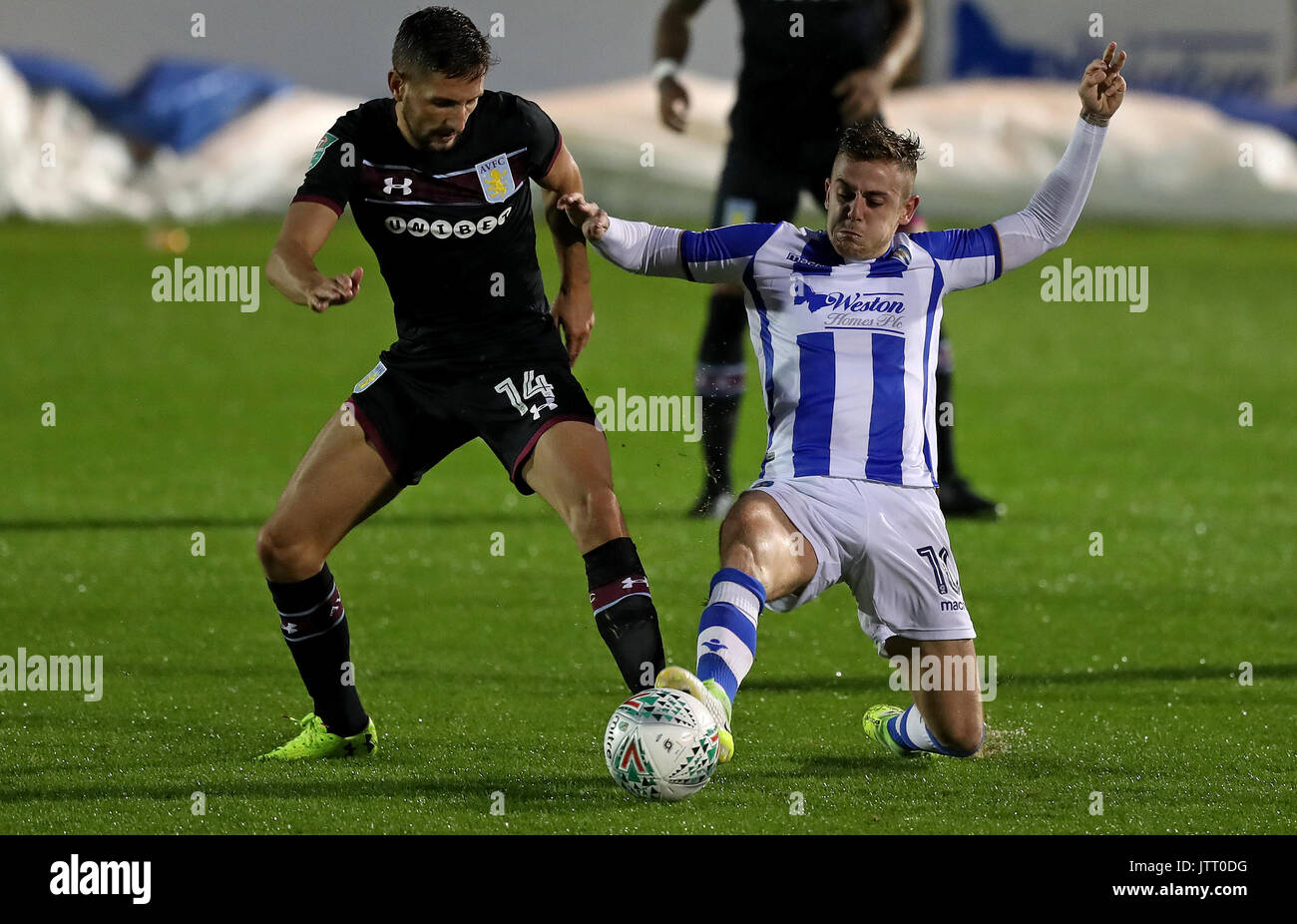 Aston Villa Conor Hourihane (sinistra) e Colchester Regno il fido Szmodics battaglia per la sfera durante il Carabao Cup, primo round in abbinamento a Weston Homes Comunità Stadium, Colchester. Foto Stock