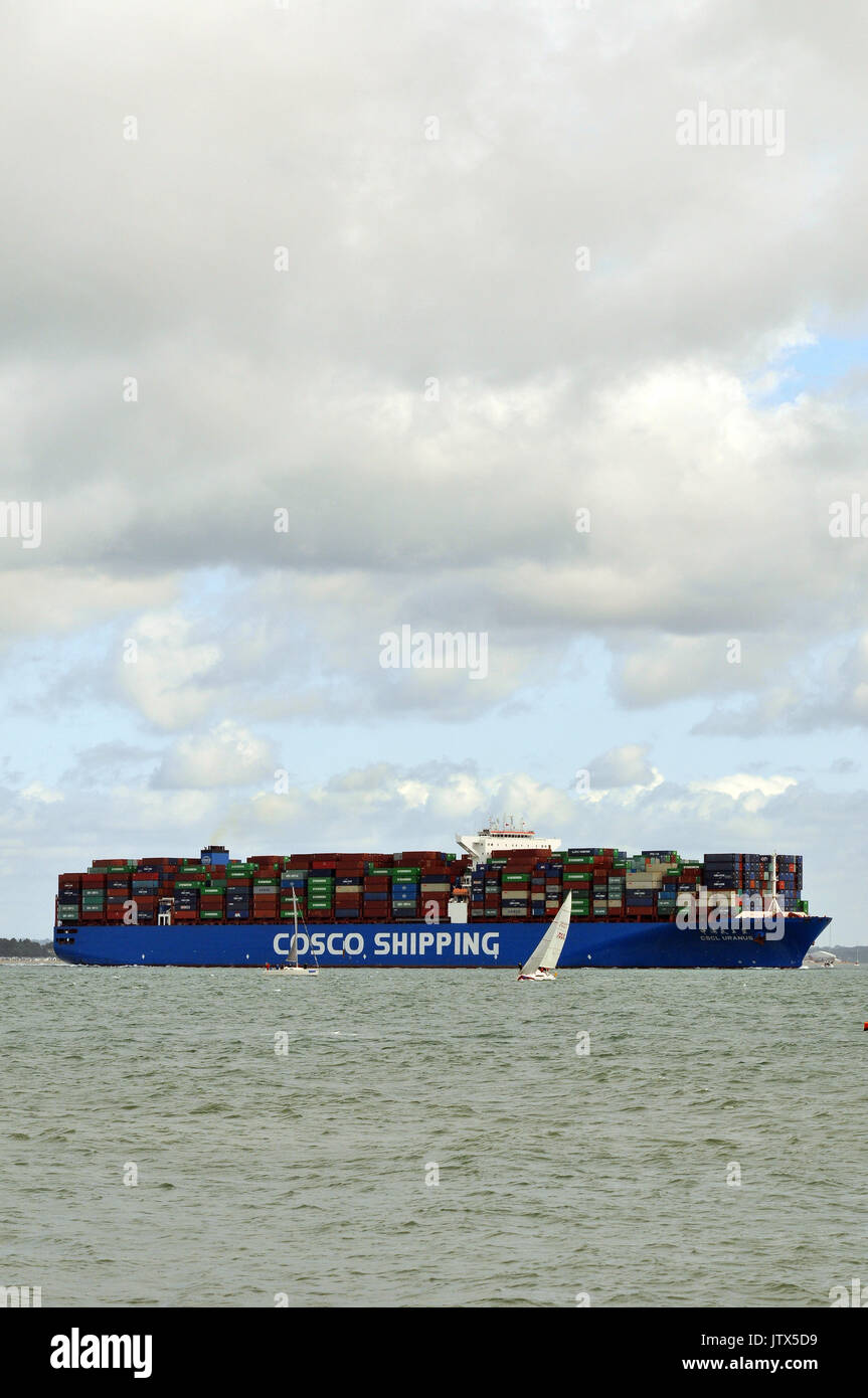 Un contenitore grande nave navigatimg Southampton acqua thorn canale durante la cowes week sull'isola di Wight con uno yacht vicino dal tahat può essere un pericolo Foto Stock