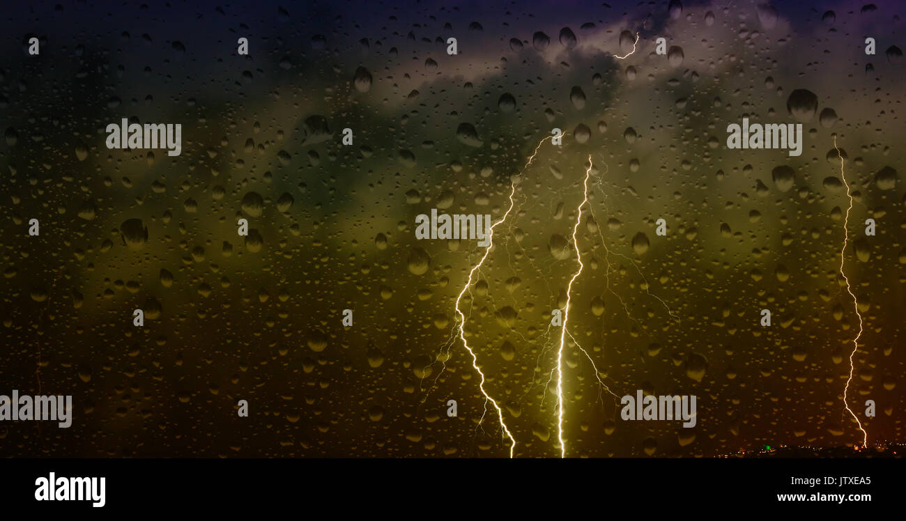 Guardando attraverso una finestra Misty con gocce di pioggia a fulmini durante una tempesta Foto Stock