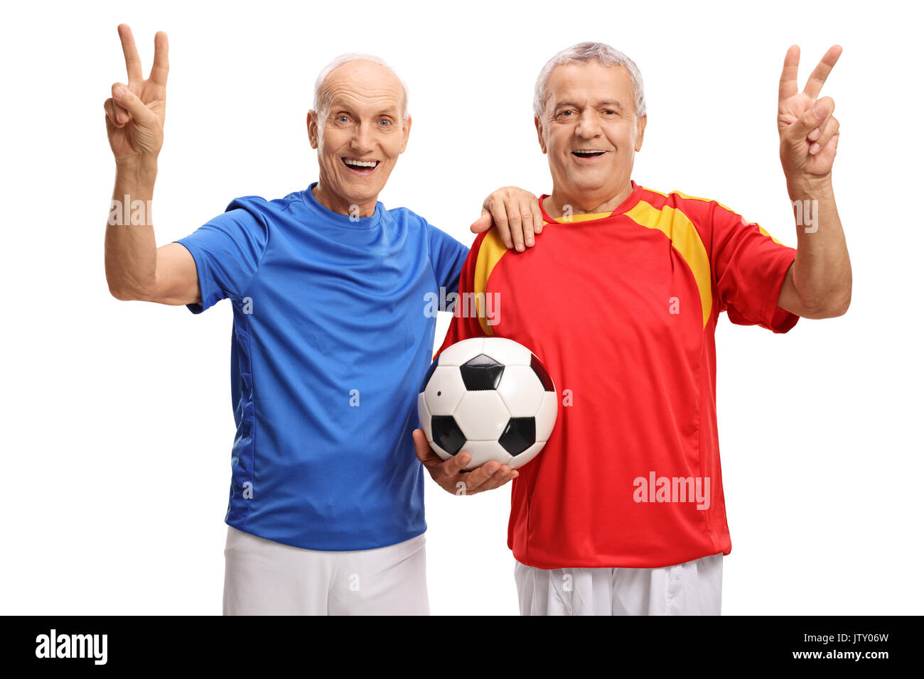 Anziani giocatori di calcio tenendo un calcio e rendendo la vittoria segni isolati su sfondo bianco Foto Stock