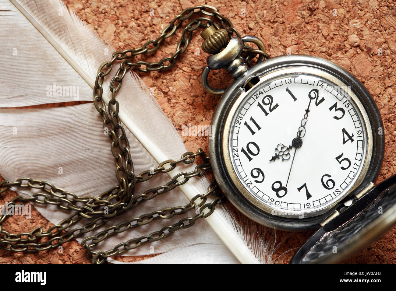 Il vecchio orologio da tasca vicino giù sul sughero sfondo di legno Foto Stock