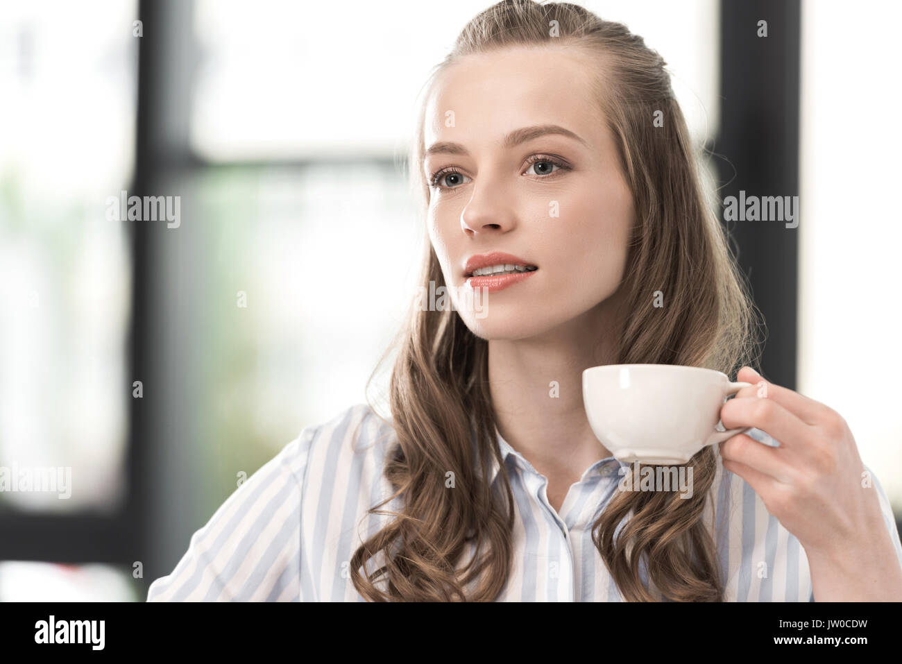 Ritratto di donna pensieroso holding tazza di caffè in mano Foto Stock