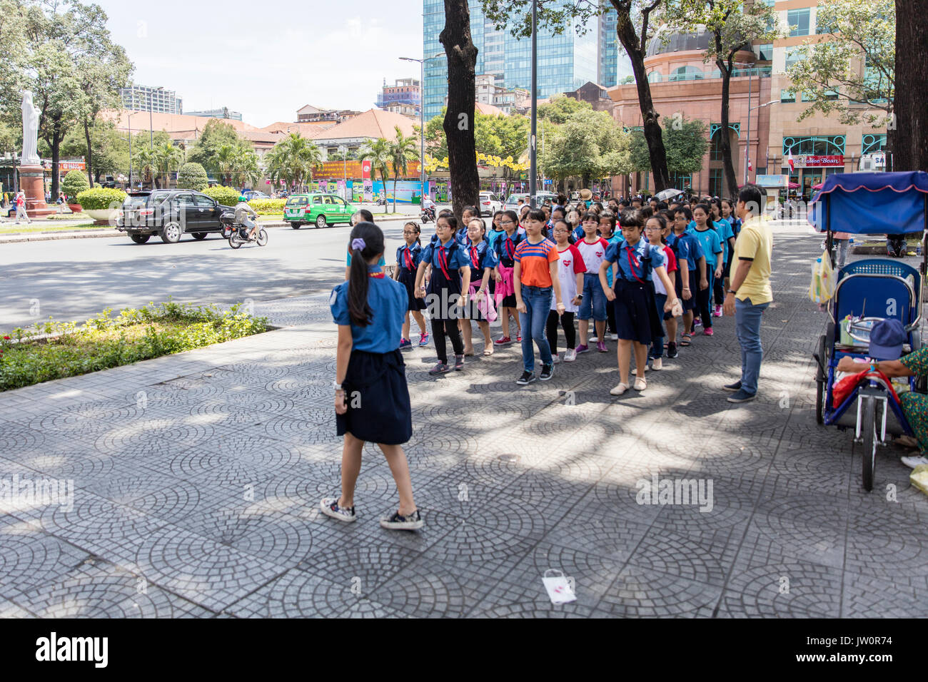 La scuola non identificato i bambini in marcia su una strada di Ho Chi Minh, Vietnam. Foto Stock