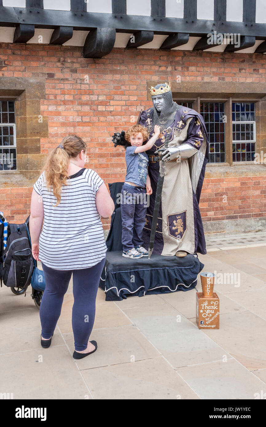 Un ragazzo ha la sua foto scattata con una statua vivente artista mime a Stratford-upon-Avon Foto Stock