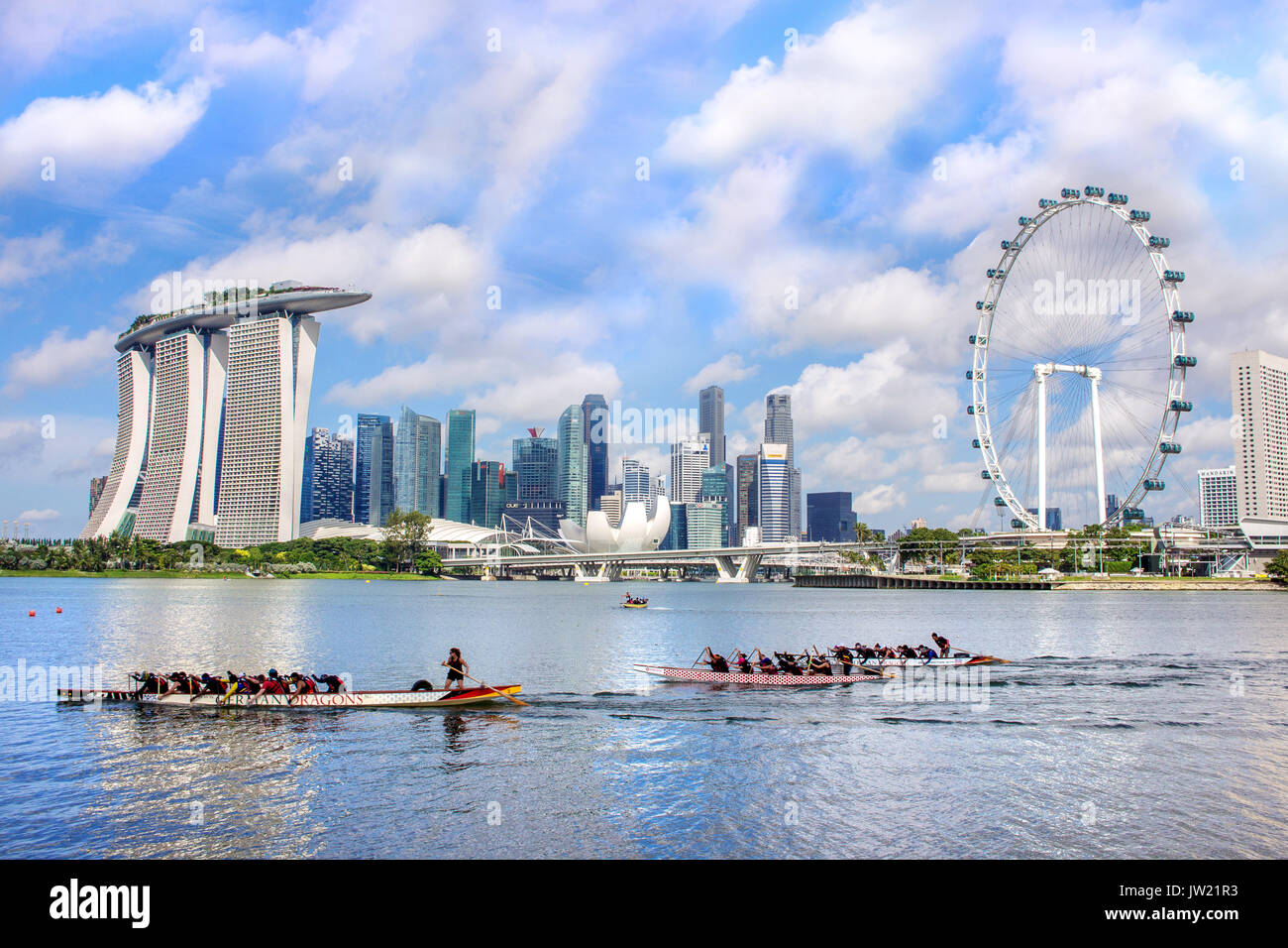 Il paesaggio della città di Singapore il distretto finanziario con il Marina Bay sands hotel ang Singapore Flyer, con persone che praticano dragon boat kayak come per Foto Stock