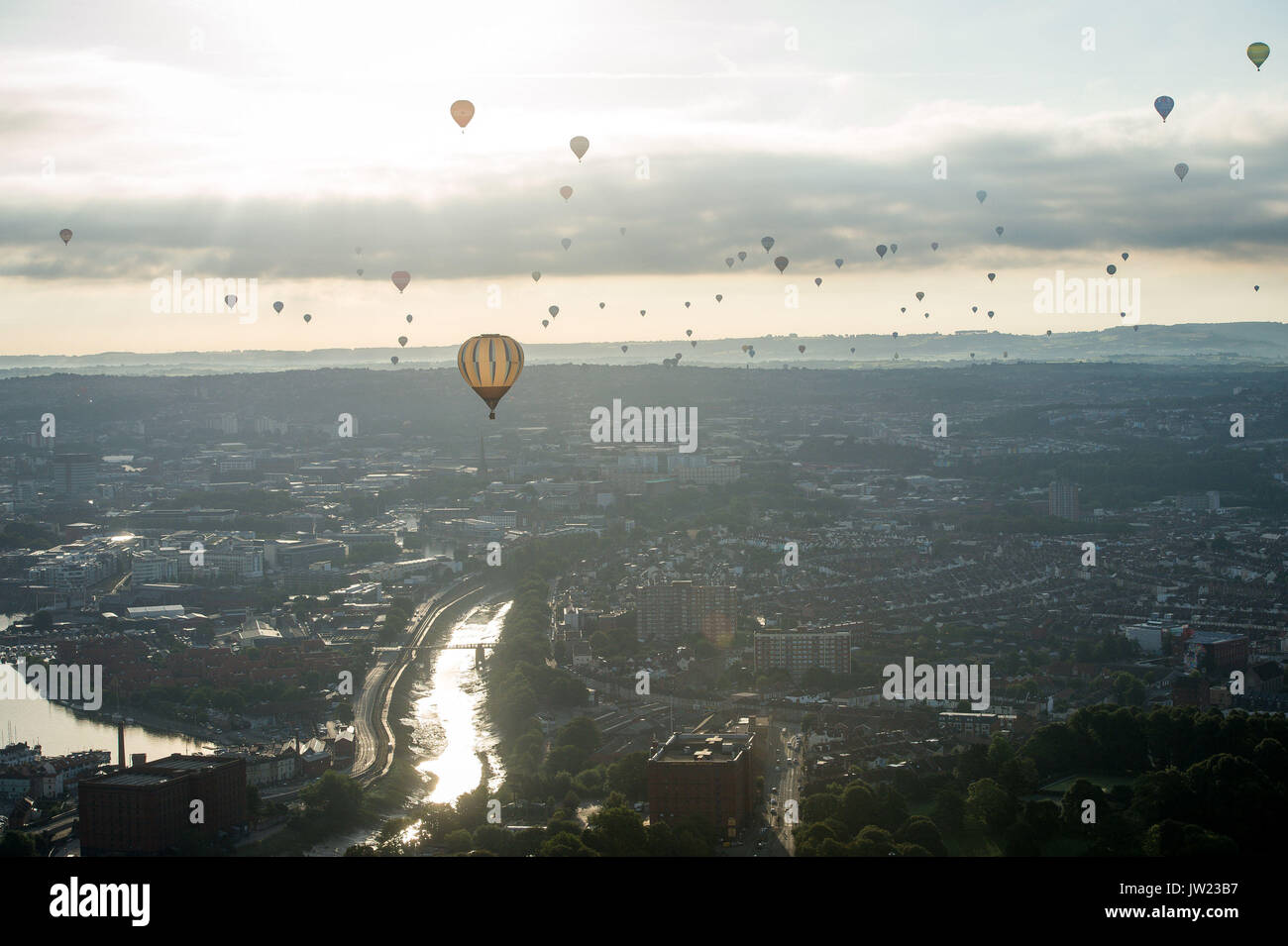 Il sole si riflette sul fiume Avon come mongolfiere volare sopra la città di Bristol durante la prima salita di massa, dove mongolfiere provenienti da tutto il mondo si riuniranno a Ashton Court, Bristol, a prendere parte al Bristol International Balloon Fiesta. Foto Stock