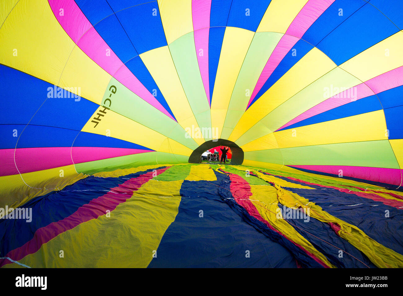 Una mongolfiera gonfia pilota durante la prima salita di massa, dove mongolfiere provenienti da tutto il mondo si riuniranno a Ashton Court, Bristol, a prendere parte al Bristol International Balloon Fiesta. Foto Stock