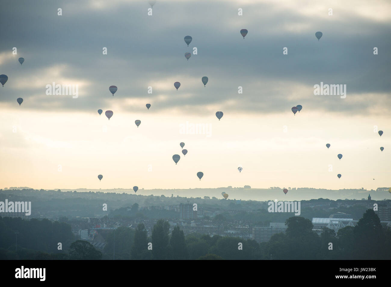 I palloni ad aria calda sorvola la città di Bristol durante la prima salita di massa, dove mongolfiere provenienti da tutto il mondo si riuniranno a Ashton Court, Bristol, a prendere parte al Bristol International Balloon Fiesta. Foto Stock
